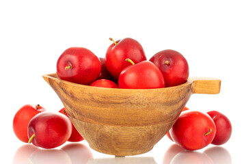 Several ripe juicy cherry plums with a wooden cup, close-up, isolated on a white background.