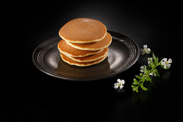 Stack of pancakes on black background.