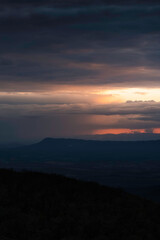 Dramatic sunset light illuminates distant downpours across the Shenandoah Valley and behind Massanutten Mountain.