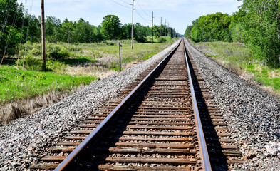 Fototapeta na wymiar Long empty railroad tracks on summer day