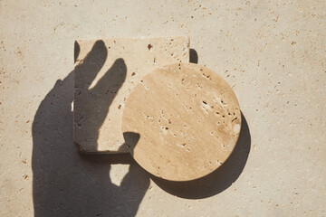 Travertine stone display flat lay podium on travertine stone background and hand shadow. Product...
