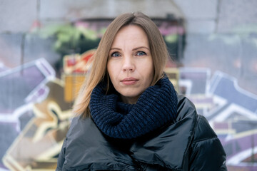 A middle-aged woman in a warm jacket in winter looks at the camera.