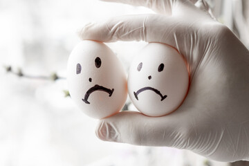 Urology concept. Male problems, infertility, decreased testosterone. Chicken eggs in hand with sad...