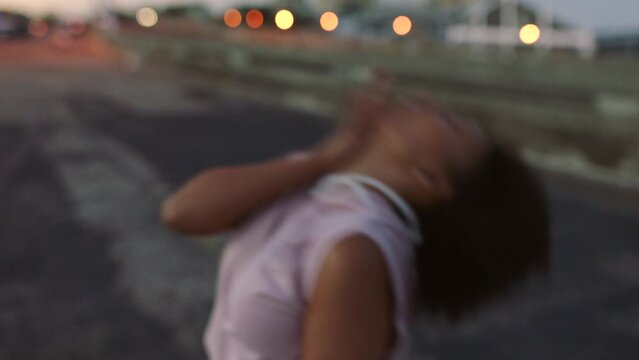 Confident freestyle dancer dancing in the city street at sunset. Handheld of trendy african modern hiphop dancer having fun and looking sexy while and enjoying the evening on urban background