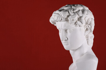 ancient white plaster head sculpture on a red background