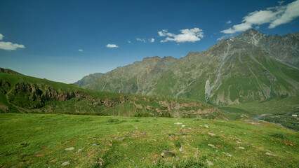 Mount Kazbek or Mount Kazbegi in Stepantsminda, Georgia daylight zooming in shot in summer with clouds in the sky in background