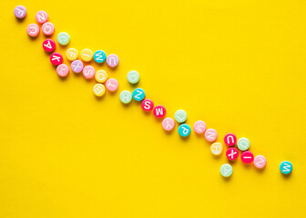 Some plastic beads with letters on yellow background