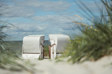 Romantic sea scene at white beach with wicker beach chair at summer sunny day