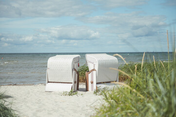Romantic sea scene at white beach with wicker beach chair at summer sunny day