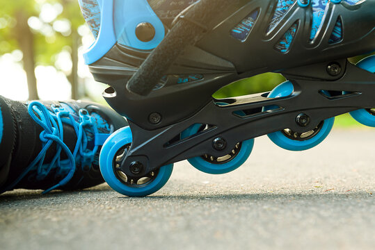 The boy puts on blue roller skates. Sport. Rollers