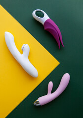 Collection of different types of sex toys on a green and yellow background.  - 518838515