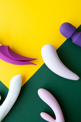 Collection of different types of sex toys on a green and yellow background.  - 518838530