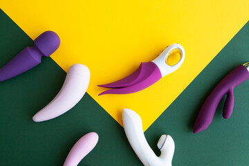 Collection of different types of sex toys on a green and yellow background.  - 518838556
