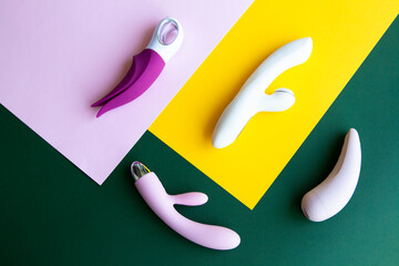 Collection of different types of sex toys on a pink, green and yellow background.  - 518838569