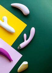 Collection of different types of sex toys on a pink, green and yellow background.  - 518838591