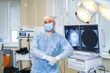 Professional emergency doctor in mask and sterile uniform. Confident surgery specialist in emergency ward.