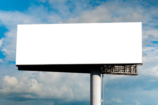 Blank Wide Large Display Or White Billboard Against Blue Sky With White Clouds - Mock Up. Template, Consumerism, Advertising, White Screen, Copy Space And Mockup Concept