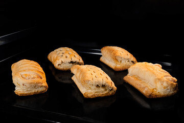 Five baked buns with ham and cheese on tray in electric oven. Homemade bakery, food, cooking and pastry concept