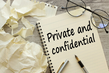 PRIVATE AND CONFIDENTIAL text in pen. on a beautiful notebook with glasses