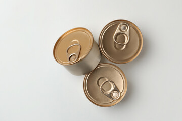 Tin cans with wet cat food on white background, top view