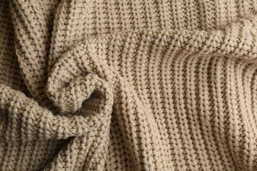 Fototapeta na wymiar Beautiful beige knitted fabric as background, top view