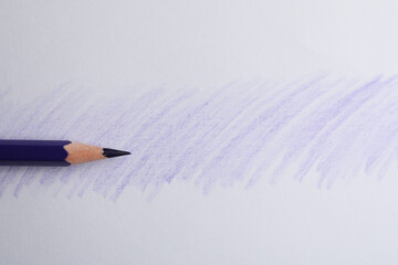 Purple pencil on sheet of paper with drawing, top view