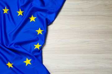 Flag of European Union on wooden table, top view. Space for text