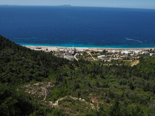 Fototapeta na wymiar Dhermi, Albania, view from the rooftop restaurant on the seaside, public beach and mountains.