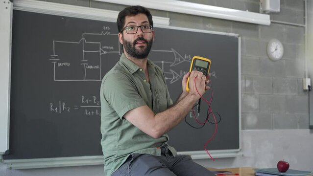Young Technology Teacher explaining electrical tester device To students learning Science and Electronics at College