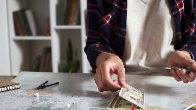 A tourist counts cash banknotes, money set aside for a trip, Preparing travel for a vacation in summer, Air travel in summer preparing a tourist route, collecting money for a trip
