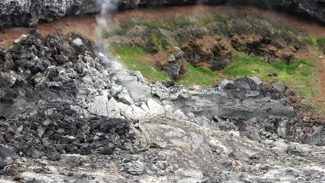 Unreal volcanic landscape in Iceland with steaming rocks on a volcano.