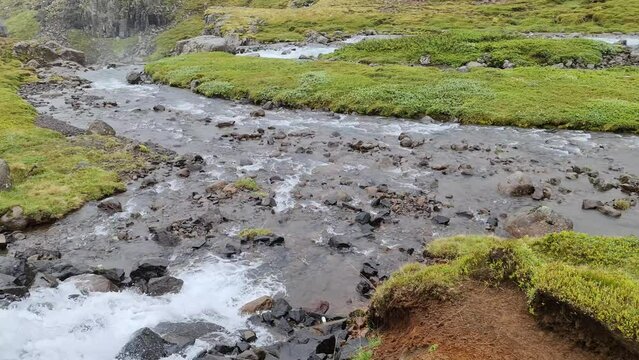 Fantastic landscape with flowing rivers and streams with rocks and grass in Iceland.