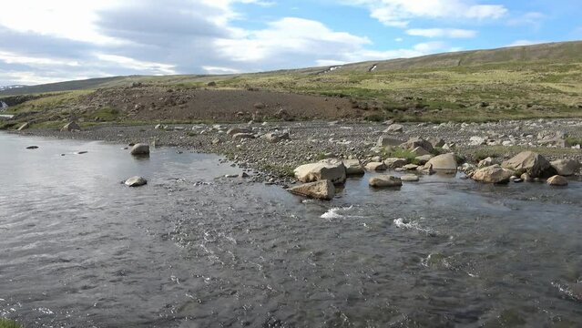 Fantastic landscape with flowing rivers and streams with rocks and grass in Iceland.