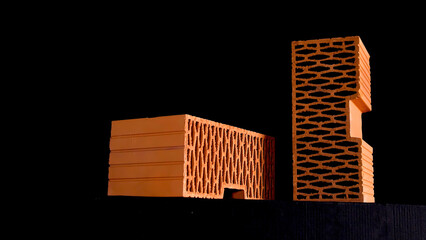 Close up of orange perforated bricks with round holes moving isolated on black background. Stock...