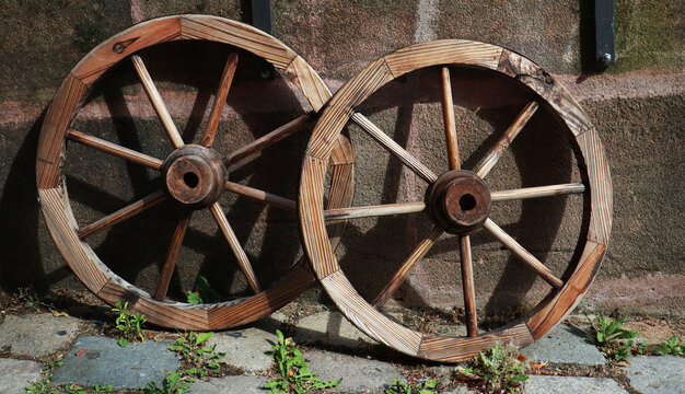 Old rustic wooden wheels on wall background           