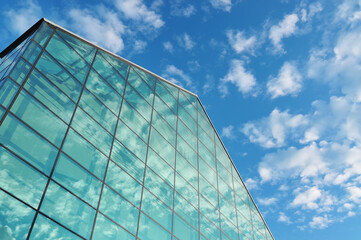 Modern office building with blue sky and clouds.