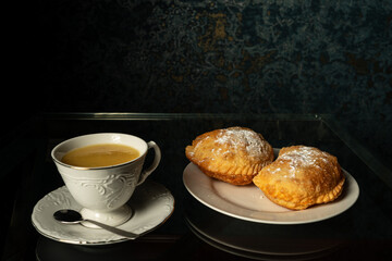 fried empanadas with cheese next to cup with yellow api, corn drink