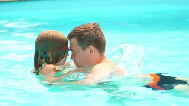 dad plays with daughter to swim in the pool. games and activities in the water.