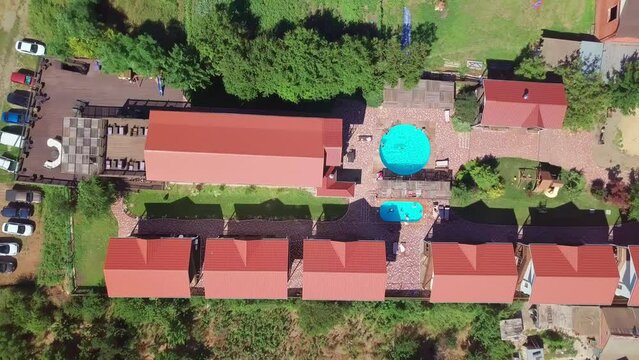 aerial photography of a country hotel with a pool on the shore of a pond.