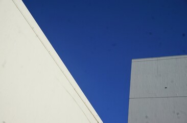 Weiße Betongebäude vor blauem Himmel bei Sonne am Nachmittag im Sommer