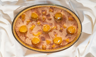 Tasty peach pie on white textile background. Top view.