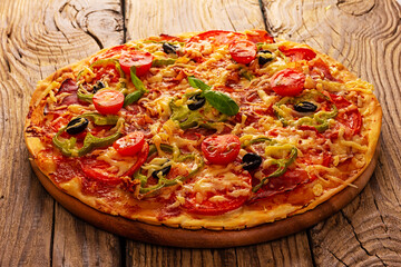 Delicious pizza served on wooden plate
