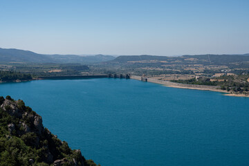 Naklejka na ściany i meble Large blue reservoir and distant hydro-electric dam