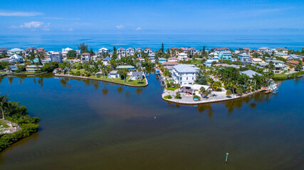 Aerial Drone View of Real Estate in Bonita Springs, Florida with the Bay in the Foreground and the Gulf of Mexico in the Background with Blue Water