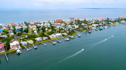 Aerial Drone View of Homes Featuring Docks on Blue Bay Waters Surrounded by Mangroves in Naples, Florida and the Gulf of Mexico in the Background with a Clear Sky