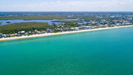 Aerial Drone View of the Coast of Bonita Springs, Florida with Barefoot Beach and Real Estate Featuring the Bay and Mangroves in the Background, and the Gulf of Mexico in the Foreground