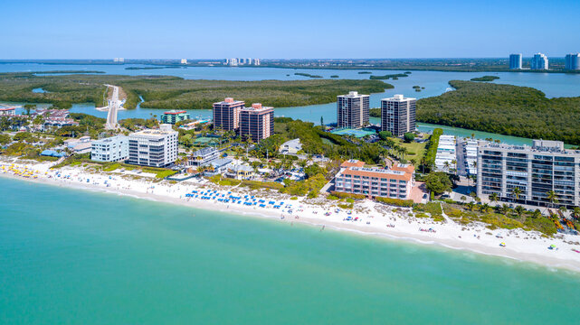 Aerial Drone View in Naples, Florida with the Coast and Sandy Beach in the Foreground on the Gulf of Mexico and Blue Water Bays in the Background Among Mangroves