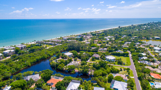 Sanibel, Florida Aerial Drone Perspective with Real Estate and Bay waters in the Foreground and Blue Water with a Beach in the Background