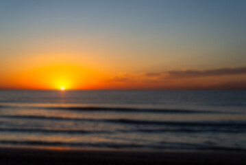 Naklejka na ściany i meble unfocused photo of a beautiful and romantic sunrise at a seashore
