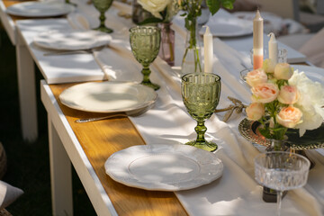 Holiday. Festive decoration. Table serving. Beautiful flower compositions. Green grass lawn. Summer pleasant meetings.